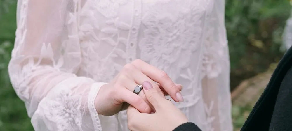 czarna obrączka na środkowym palcu prawej dłoni