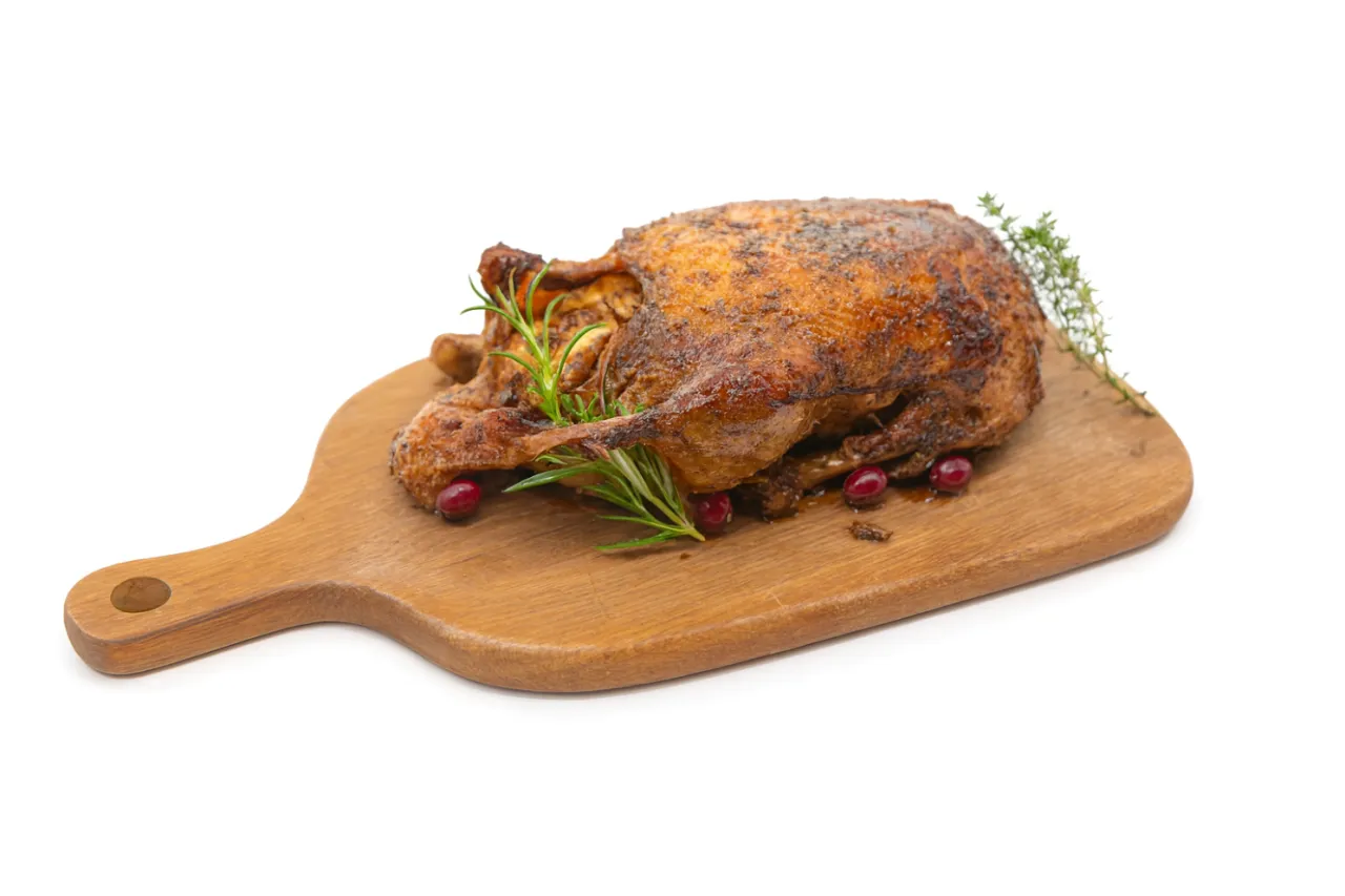 Złocista kaczka pieczona z jabłkami i żurawiną na desce, gotowa do podania. Czy lepsza od gęsi?