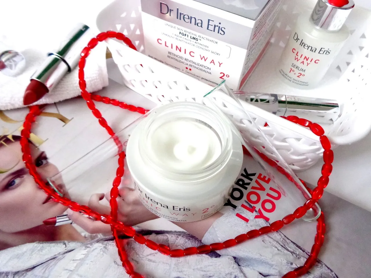 Dr Irena Eris Clinic Way dermokapsułki rewitalizujące. Krem i serum na tle magazynu z czerwoną biżuterią.