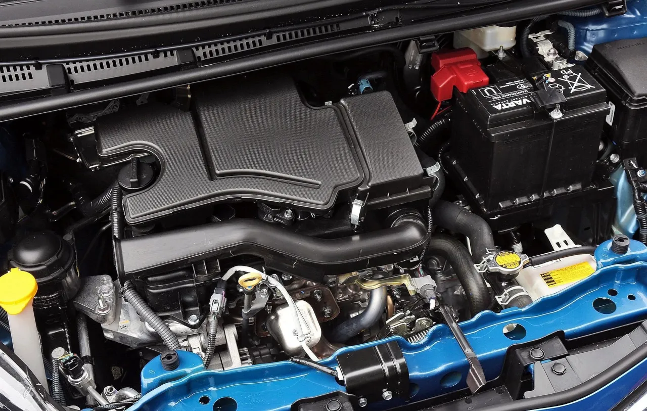 Silnik Toyoty Yaris, czysty i zadbany, gotowy do drogi. Widać akumulator Varta i elementy układu chłodzenia.