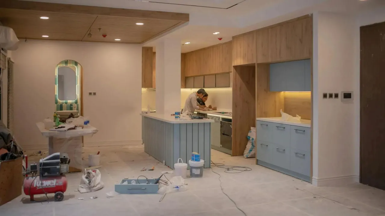 Trwa wykańczanie kuchni w stanie deweloperskim. Widać montaż mebli, sprzętów i detali.