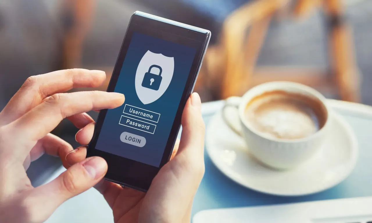 Dłonie trzymają smartfon z ekranem logowania bankowości. Dowiedz się, jak zmienić identyfikator mBank, aby zwiększyć bezpieczeństwo.