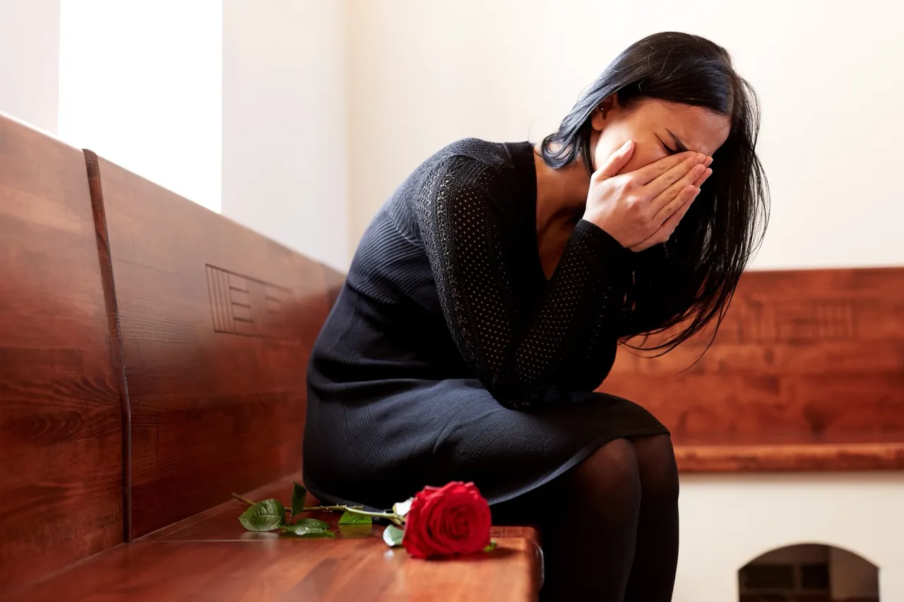 Smutna osoba trzymająca wieniec