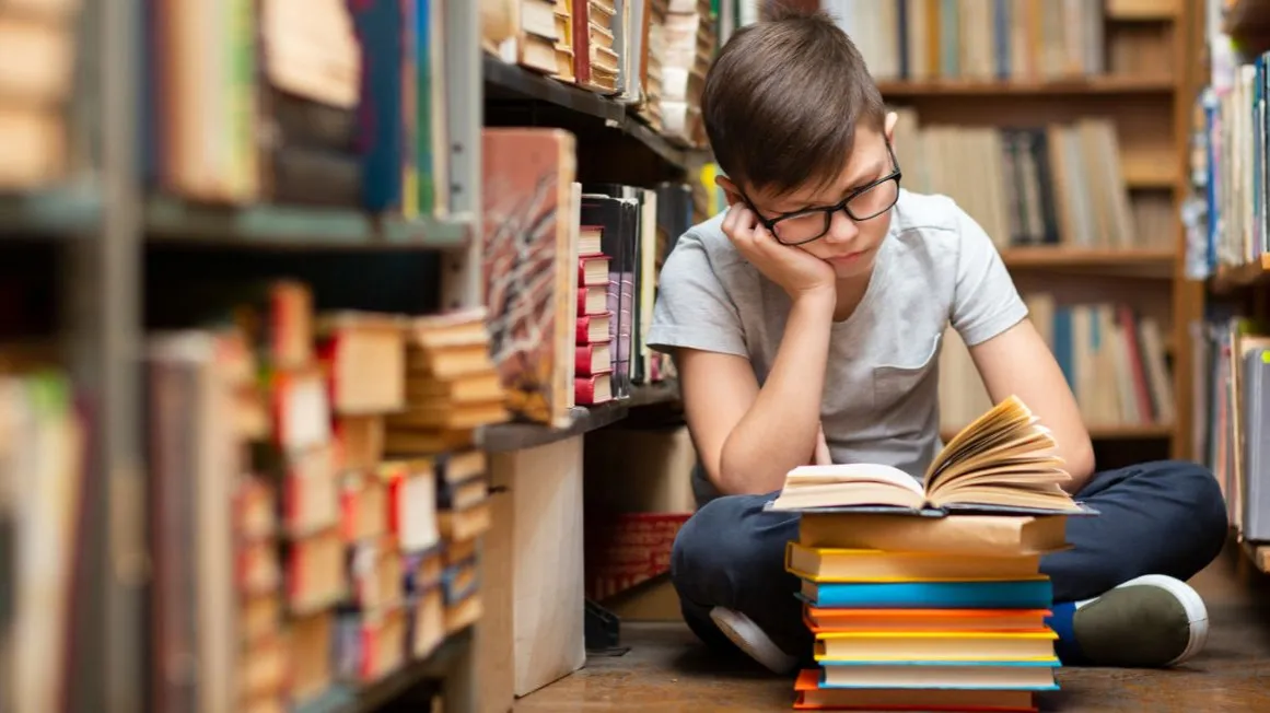 dzieci w bibliotece czytające książki