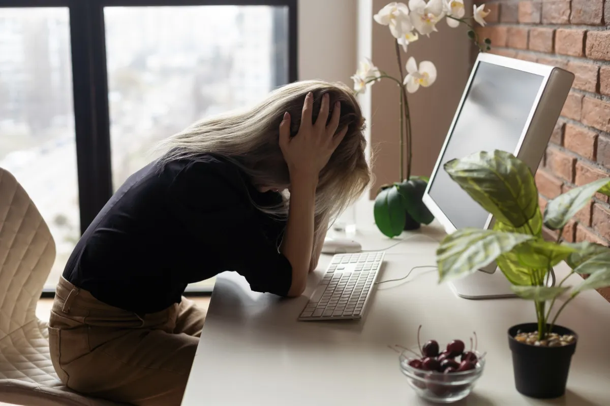 Osoba trzymająca się za głowę lub brzuch, symbolizująca b&oacute;l somatyczny