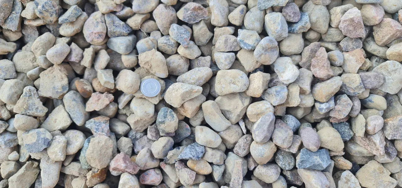 Mnóstwo kamieni różnej wielkości i koloru, idealnych do ogrodu. Zastanawiasz się, gdzie kupić żwir? Ten obraz pokazuje, jak może wyglądać.
