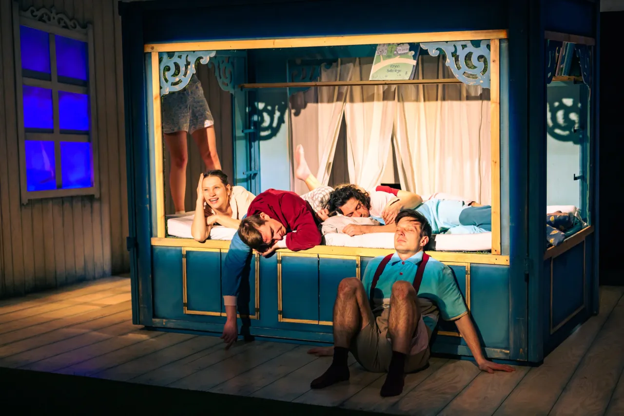 Aktorzy w łóżku na scenie, przygotowują się do przedstawienia teatralnego dla dzieci.