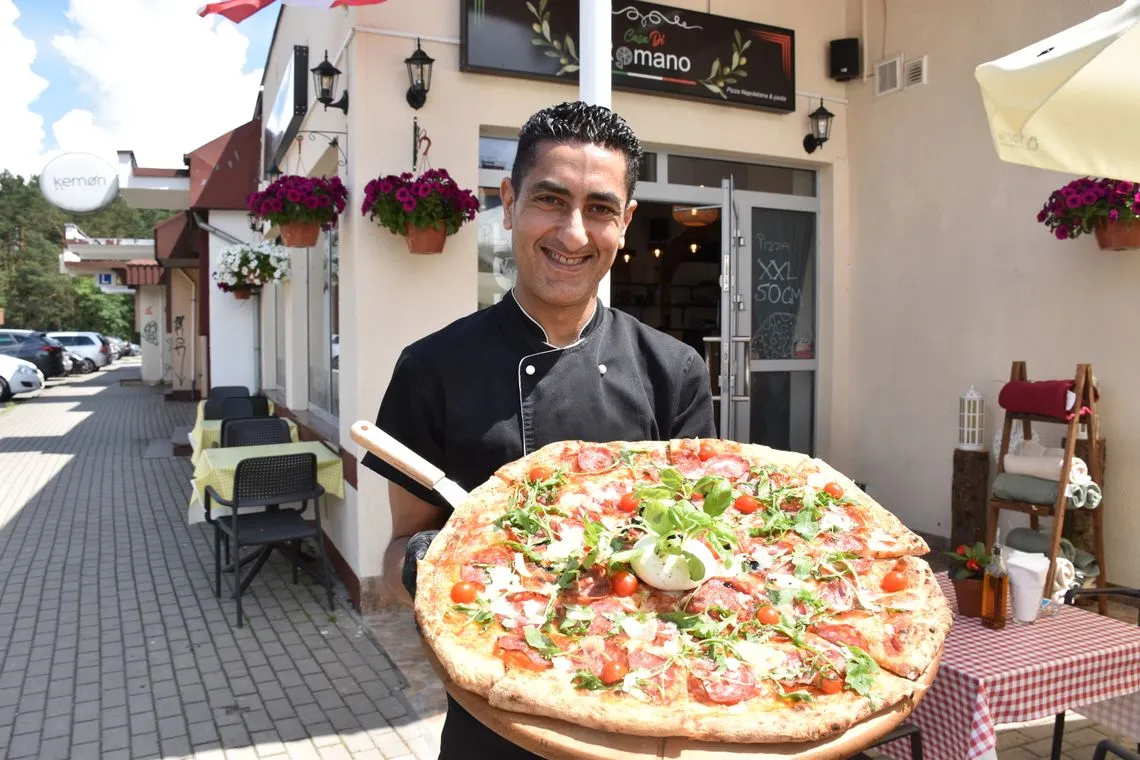 pizza 50 cm na stole z ludźmi