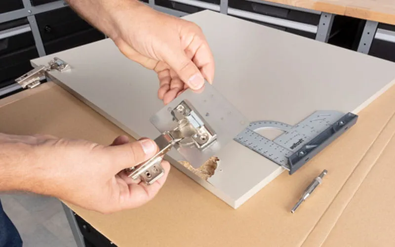 narzędzia do montażu zawias&oacute;w meblowych na stole warsztatowym