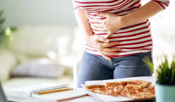 Person mit Oberbauchschmerzen und Unwohlsein nach dem Essen