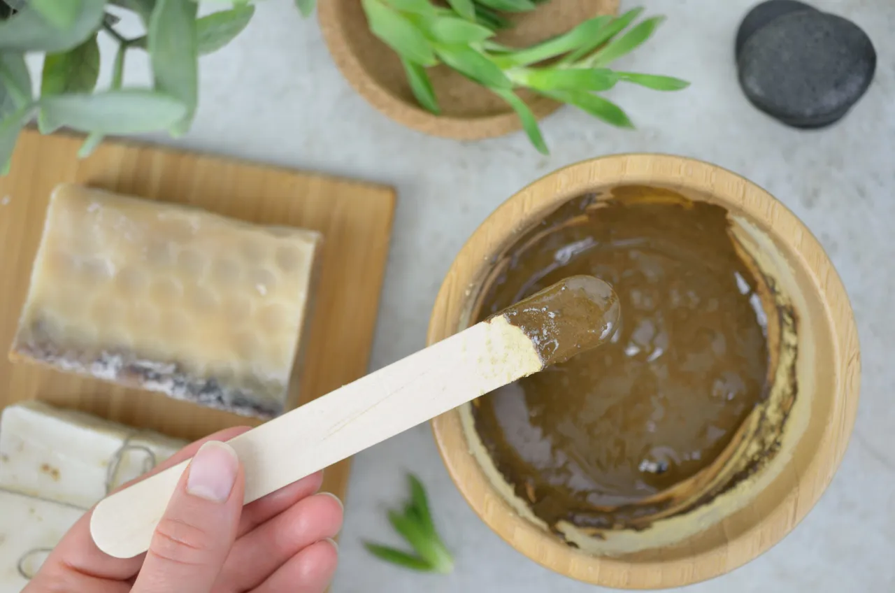 Kobieta nakładająca maseczkę z glinki na twarz