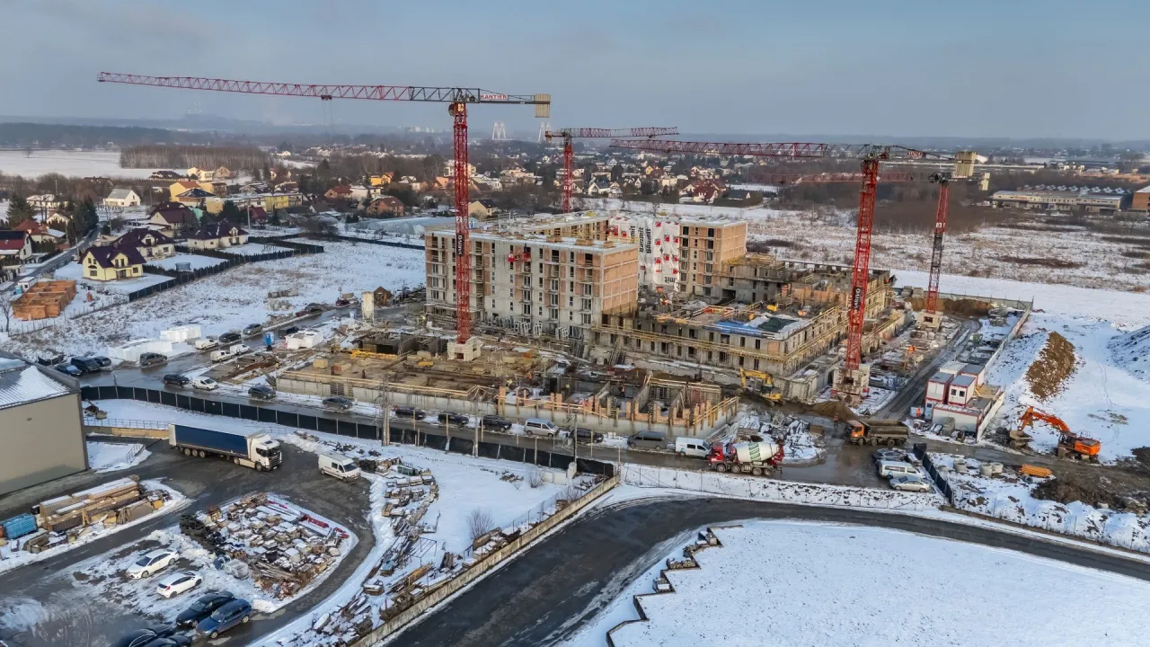 Budowa osiedla w zimowej scenerii. Dźwigi i niedokończone bloki mogą sugerować prawdziwe powody dla których deweloperzy masowo wstrzymują budowy w 2026 roku.