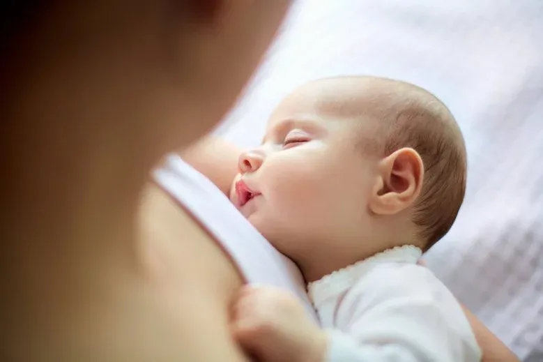 marudzące ośmiotygodniowe niemowlę w ramionach rodzica