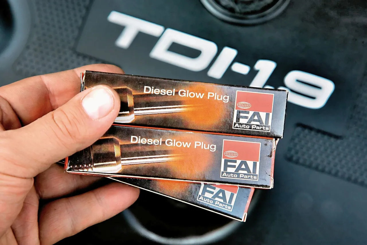 Przygotowanie do wymiany świec żarowych w silniku TDI-1.9. Dłonie trzymają opakowania świec FAI.