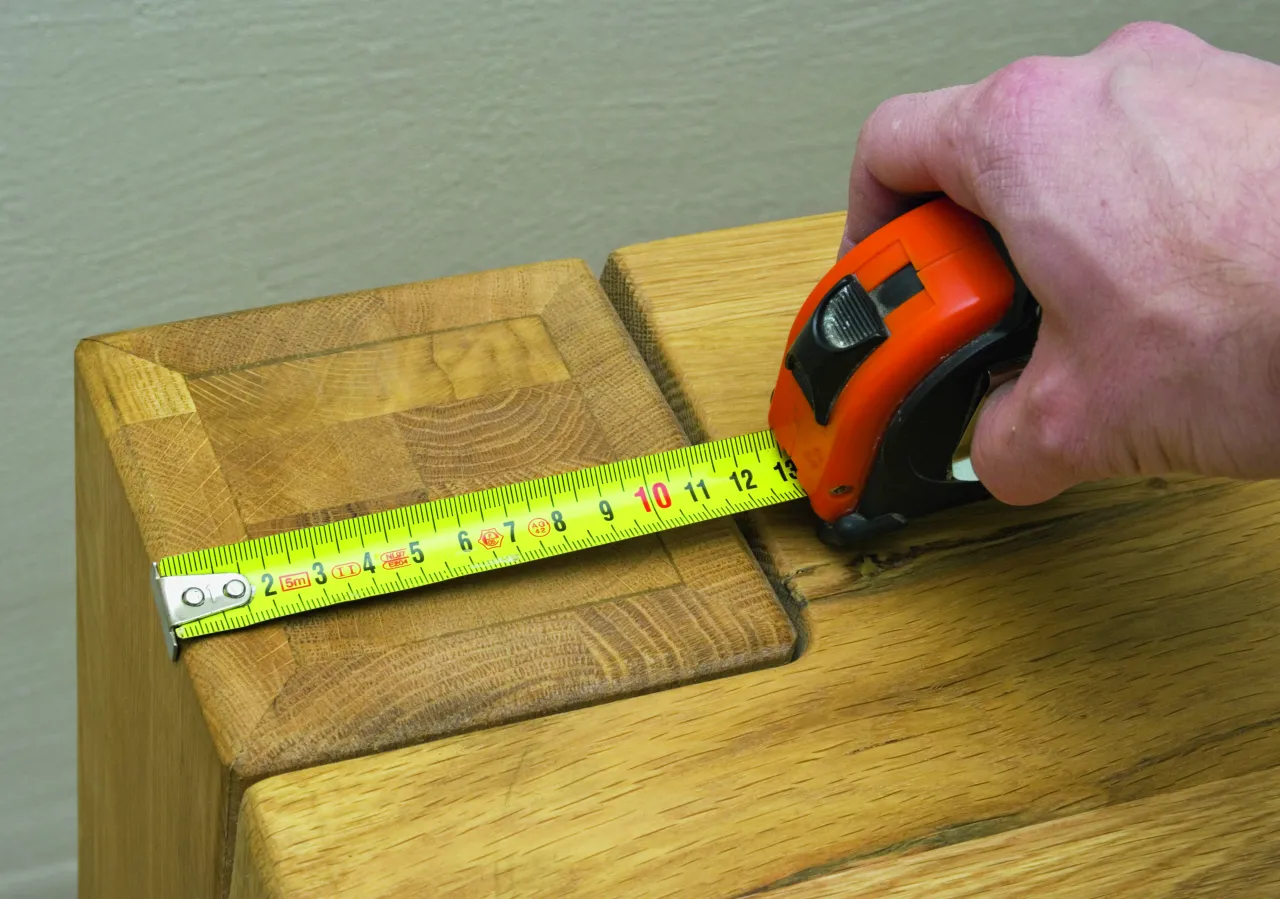 Osoba mierząca wnękę miarką metalową