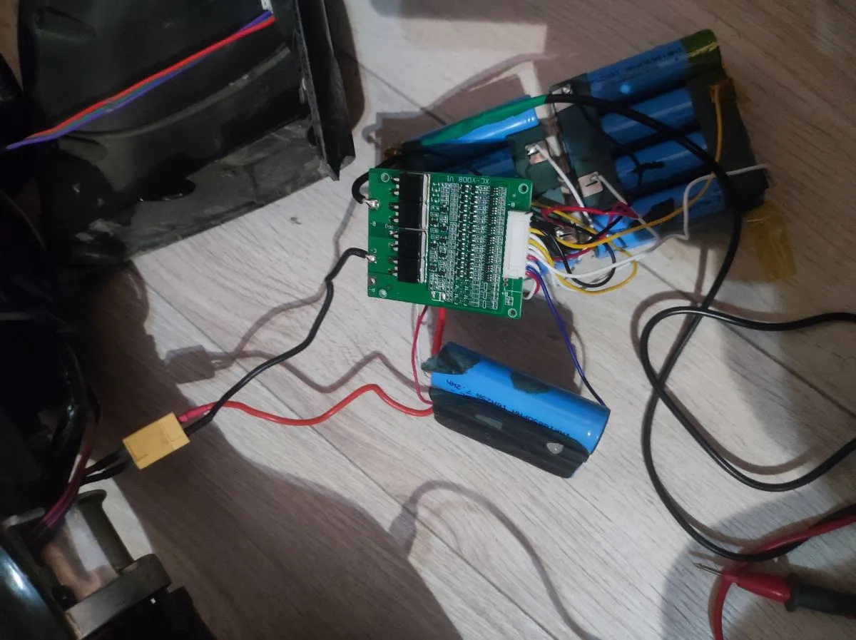 Zestaw ogniw litowo-jonowych, płytka BMS i przewody tworzą baterię do deskorolki elektrycznej.