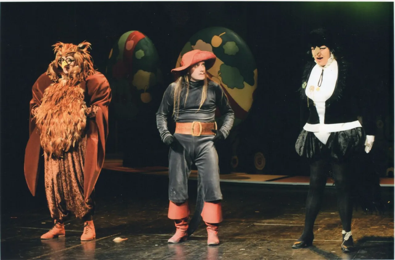 Aktorzy w kostiumach sowy, kota w butach i czarownicy na scenie. Plan wydarzeń baśni o kocie w butach.