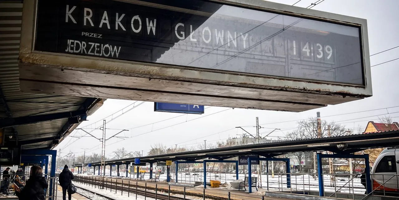 Tablica informacyjna na dworcu: pociąg do Krakowa Gł&oacute;wnego przez Jędrzej&oacute;w odjeżdża o 14:39. Z jakiego peronu?