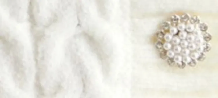 złota biżuteria i biały sweter close up