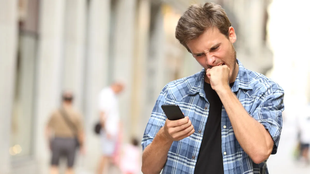 Person frustriert mit Smartphone, WhatsApp Problem