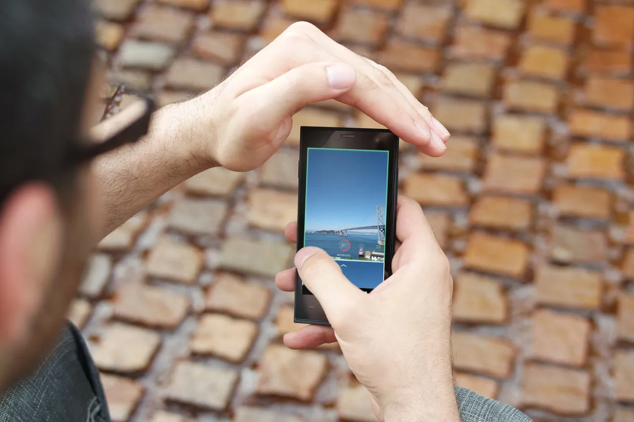 Smartfon z aplikacją do edycji zdjęć, dłoń trzymająca telefon, live photo iphone, motion photo android