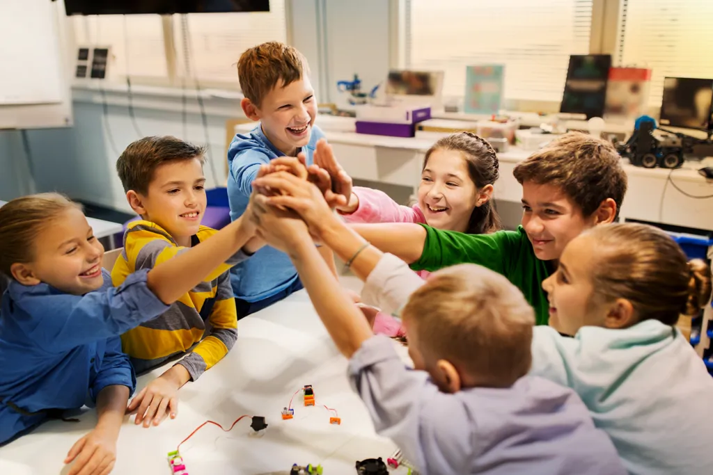 uczniowie w klasie pracujący w grupach