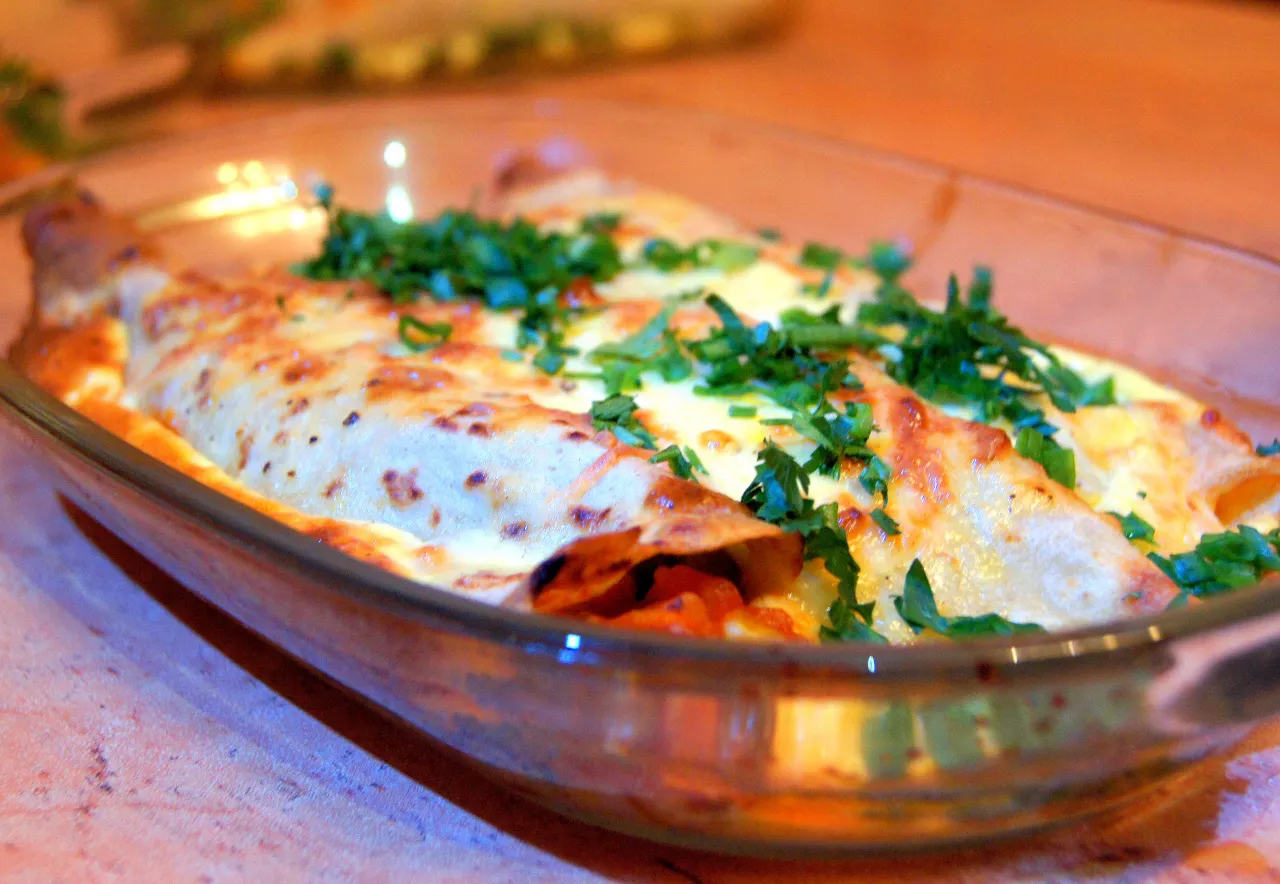 Zapiekane naleśniki z sosem bolognese, posypane serem i natką pietruszki. Idealne, gdy zastanawiasz się, co zrobić z sosem bolognese.