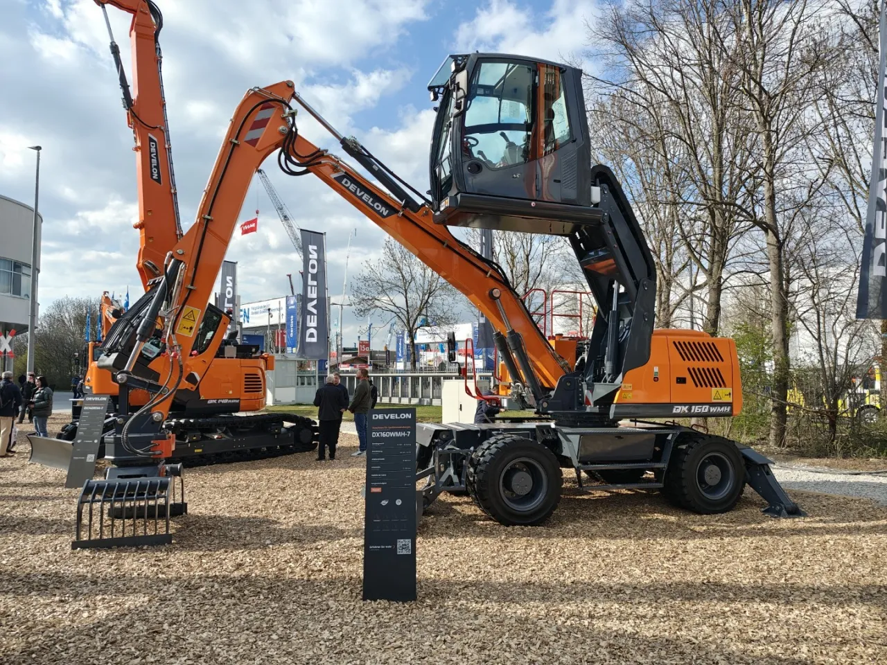 Pomarańczowe koparki gąsienicowe i kołowe marki Develon (dawniej Doosan) na wystawie. Doosan to firma znana z ciężkiego sprzętu budowlanego.