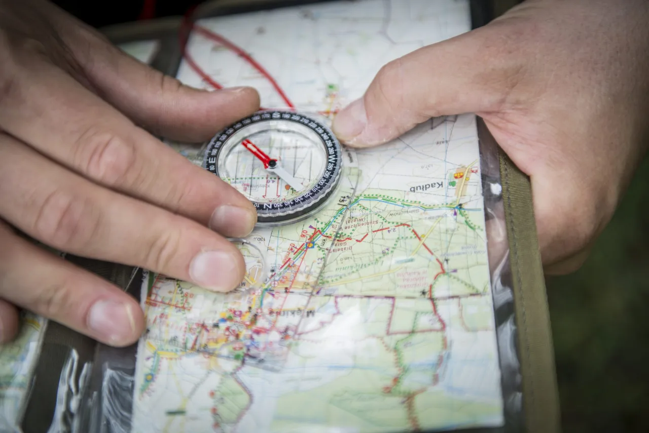 kompas tradycyjny i mapa w terenie