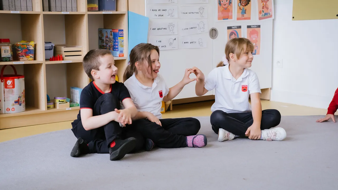 Dzieci uczące się w klasie nauczania zintegrowanego, nauczyciel wspiera aktywność