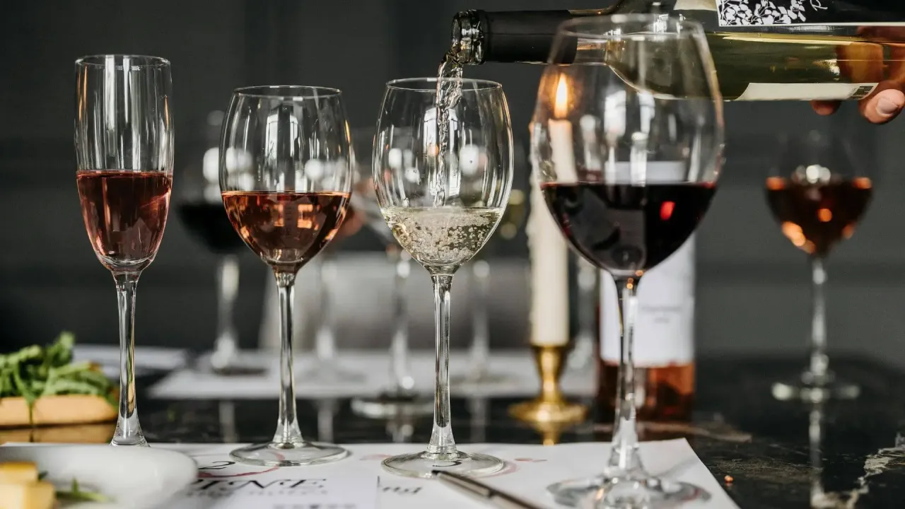 Degustacja win: ile kalorii ma kieliszek białego wina, a ile czerwonego i różowego? Kieliszki z winem białym, różowym i czerwonym na stole.