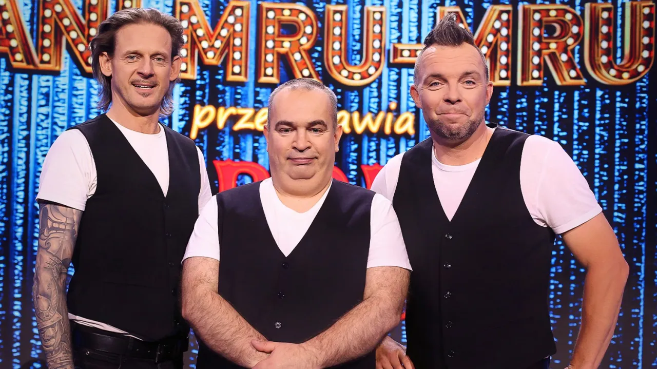 Trzech artyst&oacute;w kabaretowych, w tym Marcin W&oacute;jcik, w czarnych kamizelkach na tle scenografii z napisem 