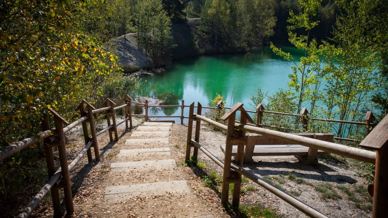 Malownicze schody prowadzące do turkusowego jeziora w Parku Mużakowskim. Idealne miejsce na odpoczynek po przejażdżce rowerowej po okolicznych trasach.
