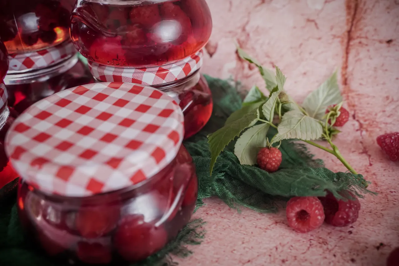 Słoiki z domowym syropem malinowym, gotowe do przechowywania. Oto jak zrobić syrop malinowy!