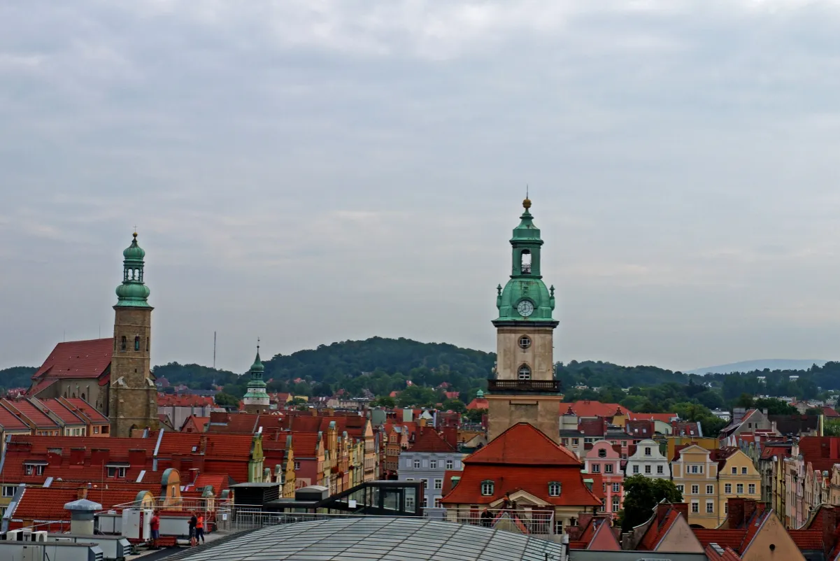 Jelenia G&oacute;ra co zobaczyć: dwie wieże kościelne g&oacute;rują nad kolorowymi kamienicami.