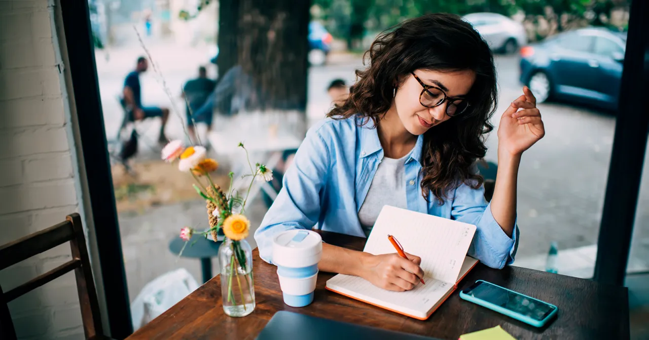 osoba pisząca w dzienniku planująca cele