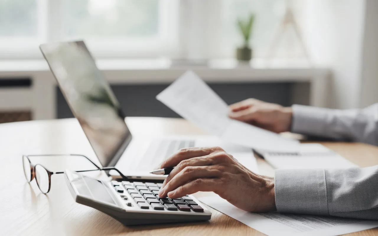 kobieta z kalkulatorem i dokumentami podatkowymi