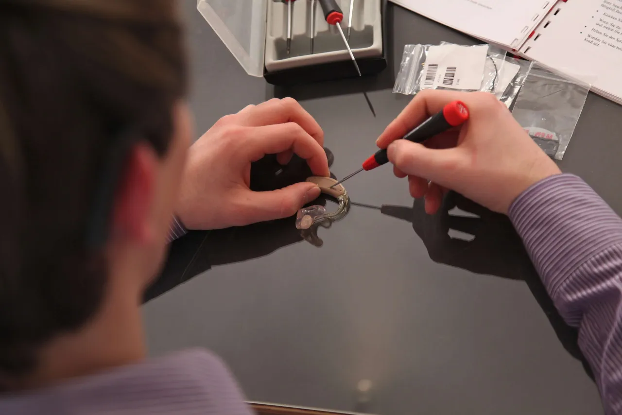 Naprawa aparatu słuchowego. Drobne elementy i precyzyjne narzędzia mogą być przyczyną, dlaczego aparat słuchowy szumi, jeśli nie są prawidłowo złożone.