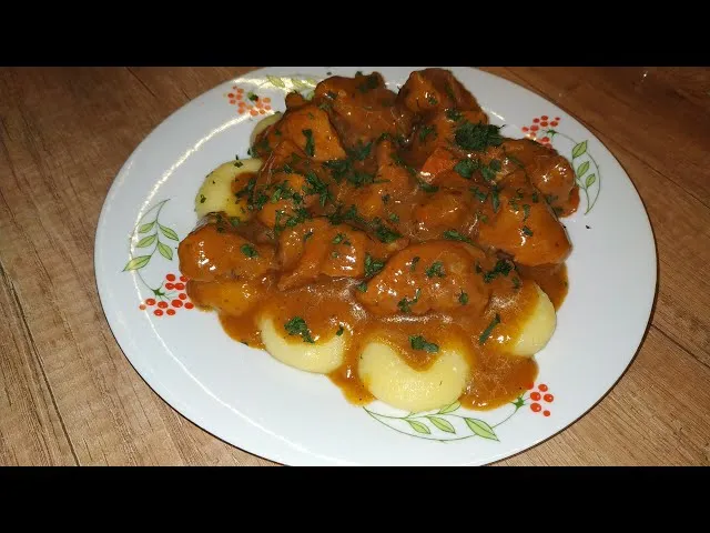 Gulasz podany z kluskami śląskimi i og&oacute;rkiem kiszonym