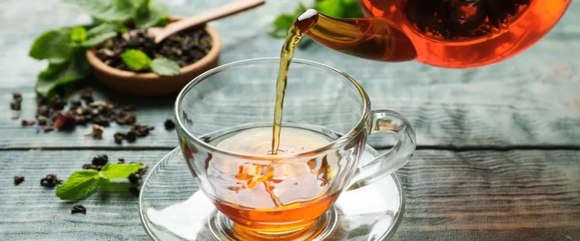 filiżanka czarnej herbaty i liście