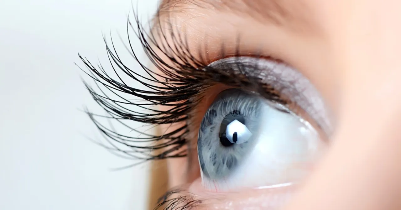 Kobieta nakładająca odżywkę do rzęs