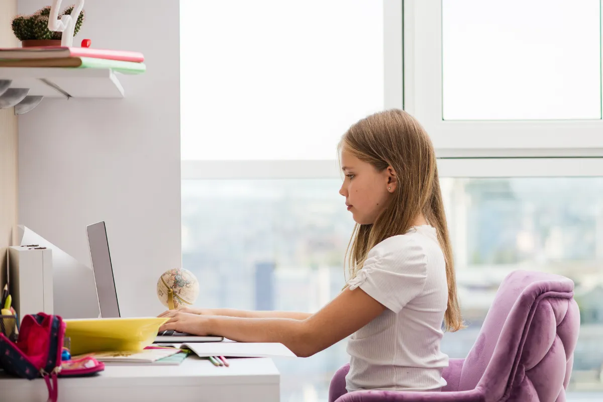 dziecko siedzące prawidłowo przy biurku krzesło bez kółek