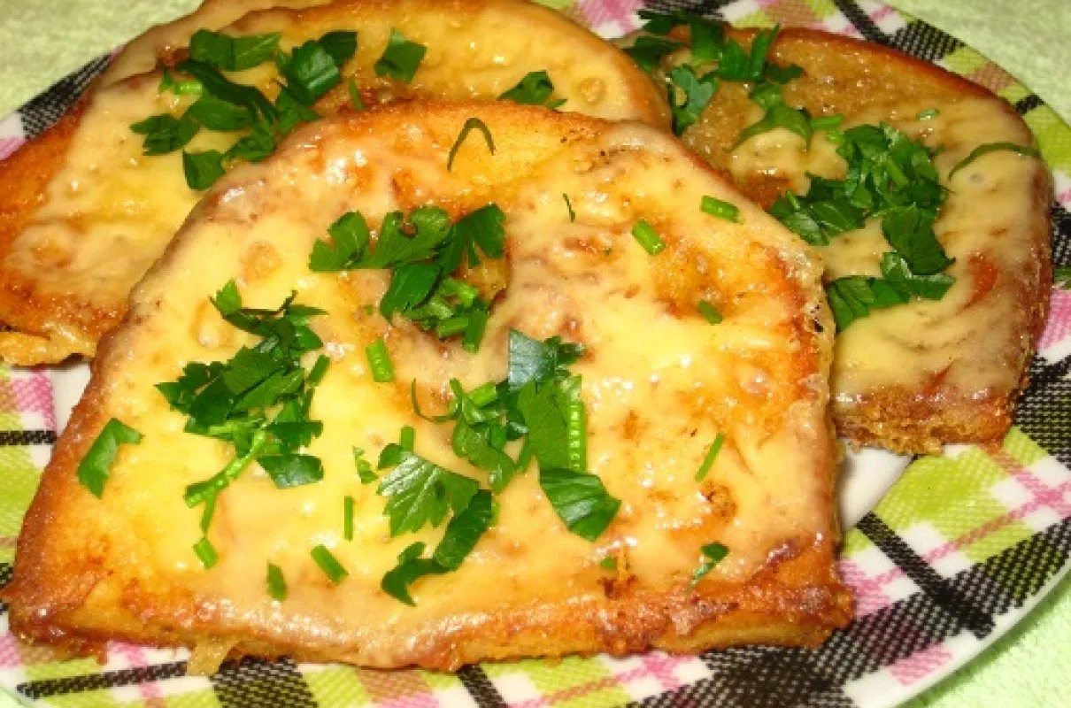 Chleb w jajku zapieczony z serem i posypany natką pietruszki. Pyszna przekąska, kt&oacute;ra pokazuje, jak zrobić chleb w jajku.