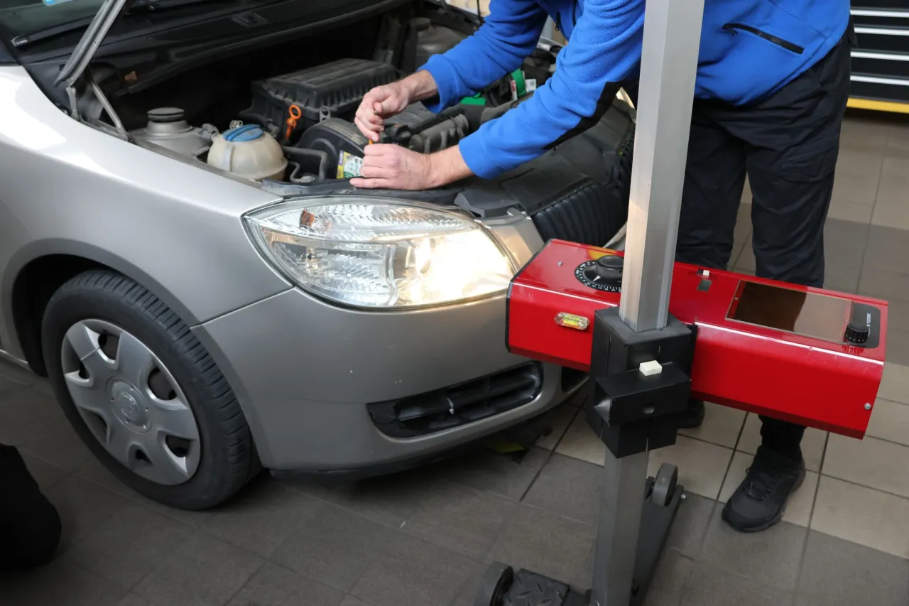 Kierowca sprawdza światła w samochodzie przed przeglądem