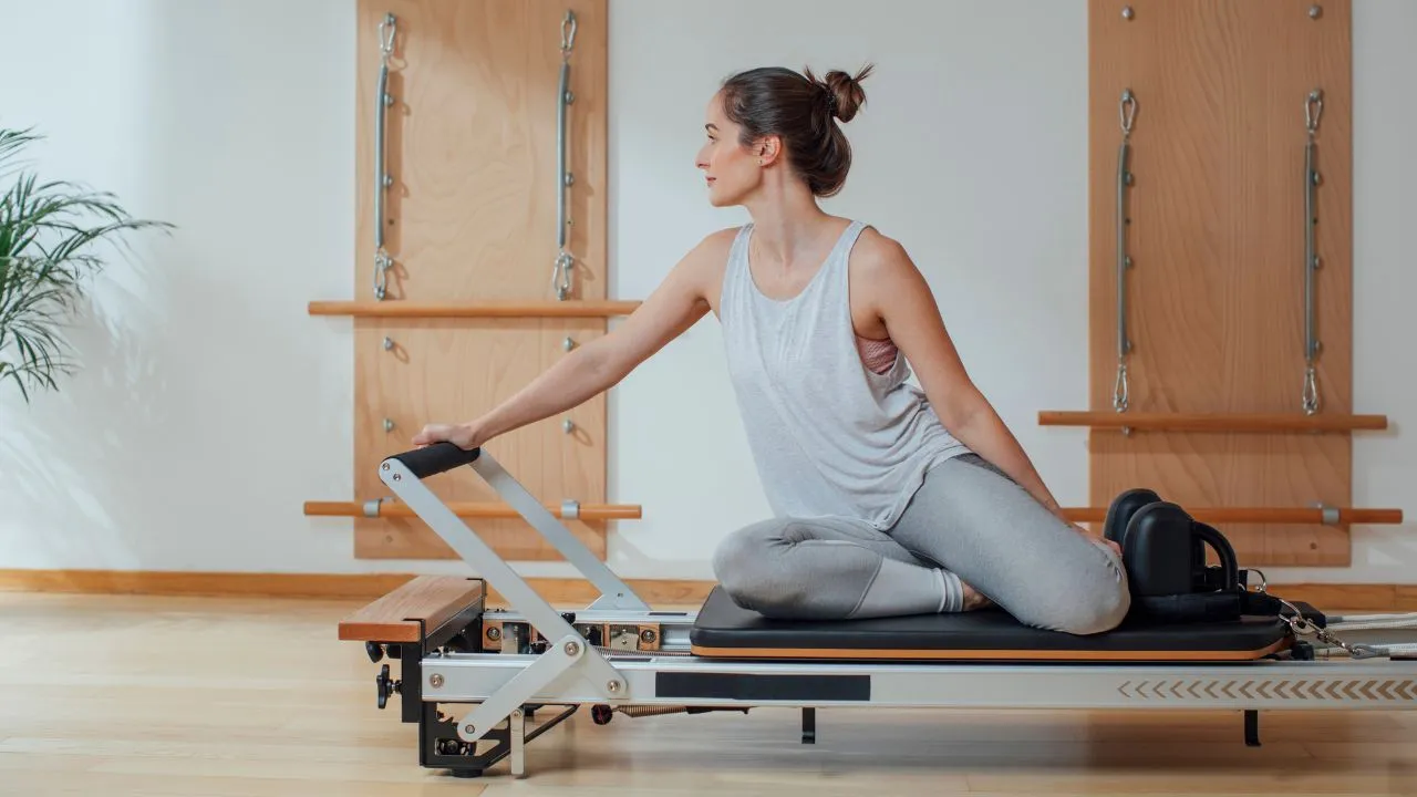 osoby ćwiczące pilates na macie i reformerze