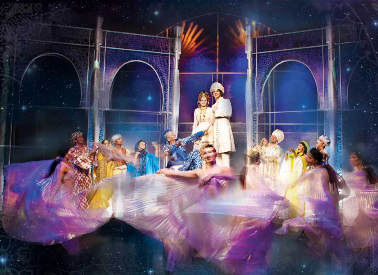 Tancerze w barwnych strojach na tle pałacowych łuków. Spektakl, który zachwyci najmłodszych – najlepsze spektakle dla dzieci Warszawa.