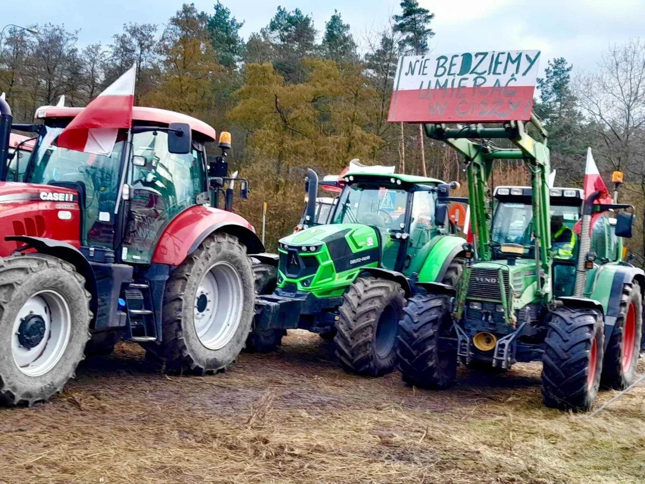 Ciągniki z polskimi flagami i transparentem 