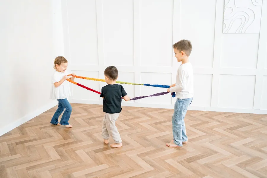 dzieci bawiące się kolorową gumą sensoryczną na podłodze