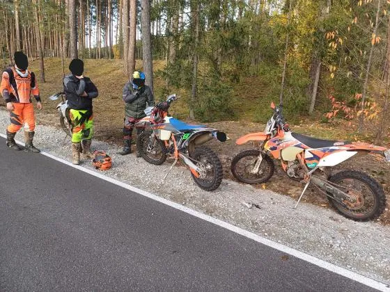 Motocykl enduro na drodze asfaltowej i w terenie leśnym