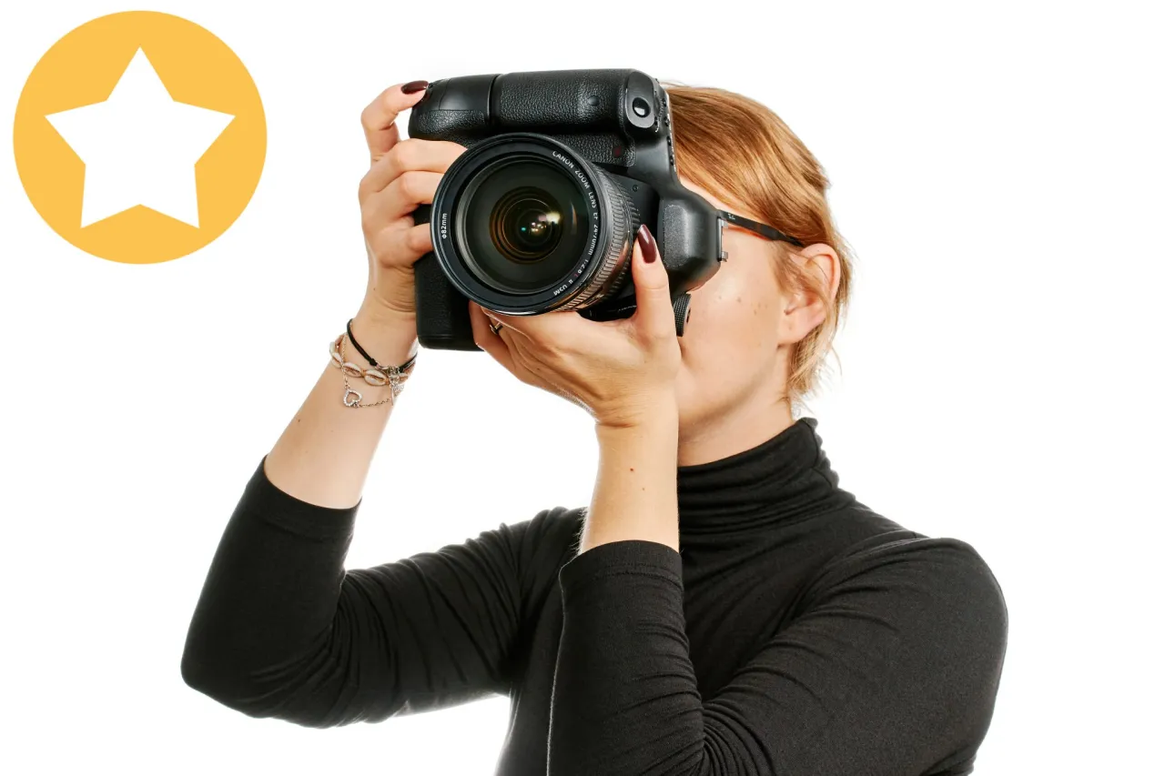 osoba trzymająca lustrzankę cyfrową
